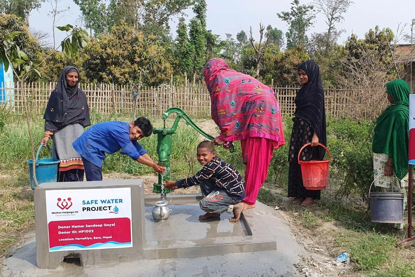 Children and women gathered around a Mother Helpage Safe Water Project hand pump in Bara Nepal